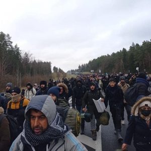 Колонна мигрантов прошла вдоль трассы к границе с Польшей. Их сопровождали люди в форме и с оружием