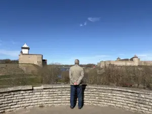 Турист в Нарве смотрит на эстонский и российский замки. Фото: Hrodna.life